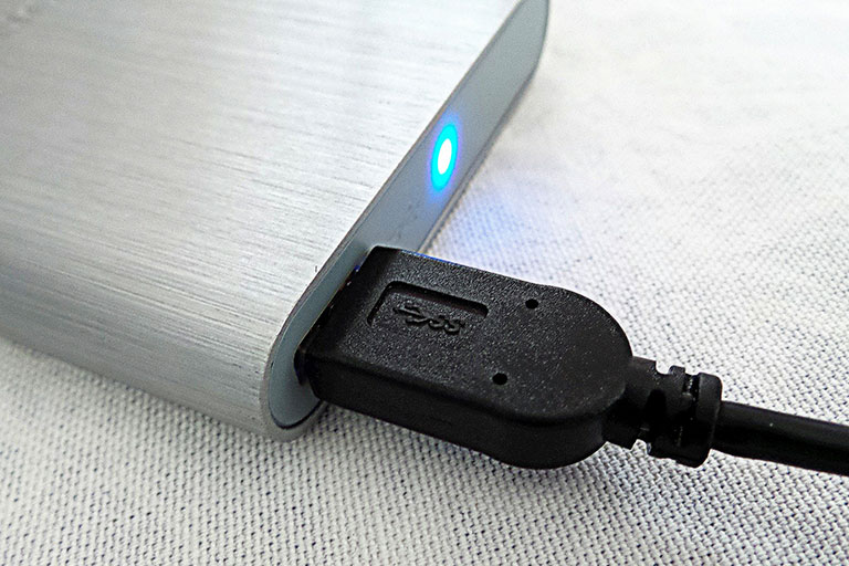 USB hard disk drive with USB cable connected and light on