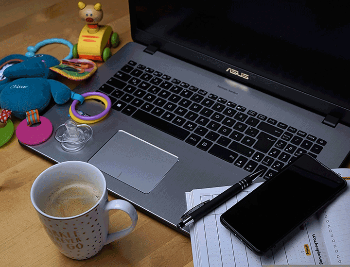 Laptop at home with coffee and childrens toys